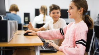 Young boy and girl using computers during lesson in computer class.