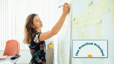 A woman writing goals on a sticky note.